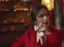 a woman in a red shirt is making a face