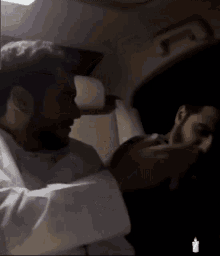 a man in a white shirt is holding another man 's hand