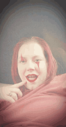a woman with red hair and a clown face paint on her face