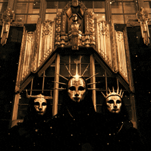 a group of people wearing masks are standing in front of a building with a statue of liberty in the background