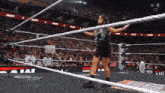 a woman is standing in a wrestling ring with a sign that says snickers on it
