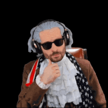 a man wearing headphones and sunglasses giving a thumbs up