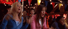 a group of people are dancing in a room with flags and lights .