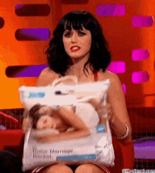 a woman is holding a pillow with a picture of a woman on it ..