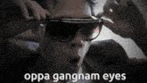 a person wearing sunglasses with the words oppa gangnam eyes on the bottom