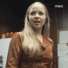 a woman is standing in front of a sign that says max on it