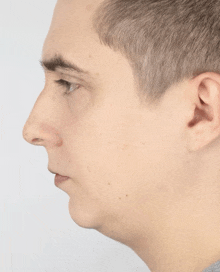 a close up of a man 's face with a gray background