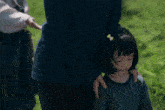 a little girl with a bow in her hair is being held by a man