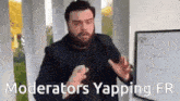 a man with a beard is standing in front of a white board with the words " moderators yapping fr " written on it