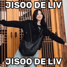 a woman with her arms outstretched is standing in front of a door with the words jisoo de liv on it