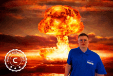 a man in a blue shirt stands in front of a large explosion with a www.cutour.pro watermark