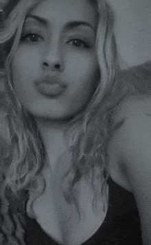 a black and white photo of a woman in a black tank top