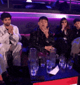 a group of people sit around a table with glasses of water