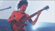 a man playing a bass guitar with the letter d on the bottom right