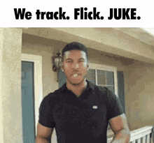 a man in a black shirt is standing in front of a building with the words we track flick juke written above him