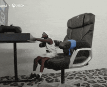 a little girl is sitting in a chair in front of an xbox monitor