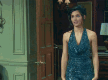 a woman in a blue dress is standing in a room