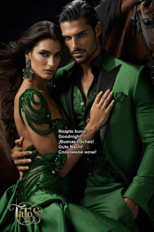 a man in a green suit and a woman in a green dress are hugging each other