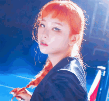 a close up of a woman with red hair and a black jacket