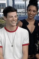 a man and a woman are sitting next to each other and laughing .