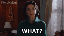 a woman in a green sweater says what in front of a window