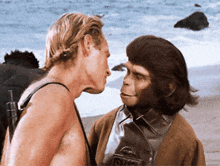 a man and a monkey are looking at each other