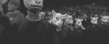 a group of people wearing sheep masks are walking in a line in a black and white photo .