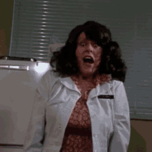 a woman in a white lab coat has a name tag that says ' a. smith ' on it