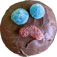 a chocolate cookie with blue and red gummy candies on it