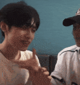 a man wearing a baseball cap and a white shirt with the letter d on it