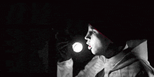 a man in a red hat and white jacket is holding a knife in his hand in a black and white photo .