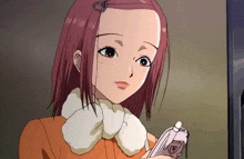 a girl with red hair is holding a pink cell phone with the letter e on it
