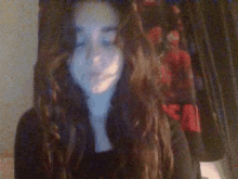 a girl with long hair is smiling in front of a blanket that says spiderman