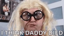 a man wearing glasses and a blonde wig is making a funny face and saying i think daddy died .