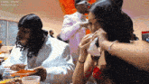 a man in a white suit and a woman in a red dress are sitting at a table with the number 12661 on the bottom