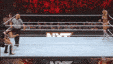 two women are wrestling in a ring with a nm logo in the background