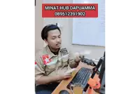 a man is sitting at a desk with a computer and a phone number that says minat hub dapuamma