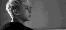 a black and white photo of a person wearing glasses .