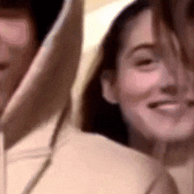 a close up of a man and a woman wearing hoodies .