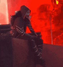a person is sitting in front of a red background .