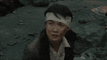 a man with a bandage on his head is looking at something