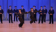a group of men in sailor uniforms are dancing on stage