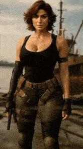 a woman in a black tank top and leather pants is holding a gun in front of a body of water .