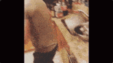 a person is standing in a kitchen next to a sink and a bowl .