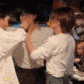 a group of people are standing next to each other and one of them is holding another person 's neck .