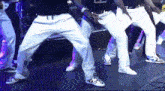 a group of men are dancing and one of them is wearing a shirt that says 9x0