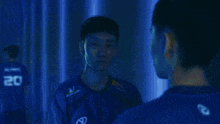 a man in a blue shirt with the number 20 on the back
