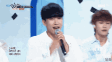 a man singing into a microphone with korean writing on it