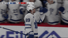 a hockey player wearing number 89 stands in front of his teammates