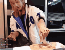 a woman wearing a jacket with the number 07 on it is cutting a piece of meat on a cutting board